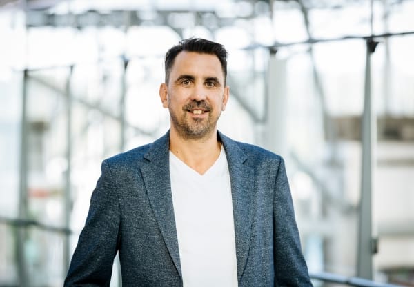 Darstellung von Dirk Kluefer, der freundlich in die Kamera schaut, in einem professionellen Porträt mit neutralem Hintergrund.