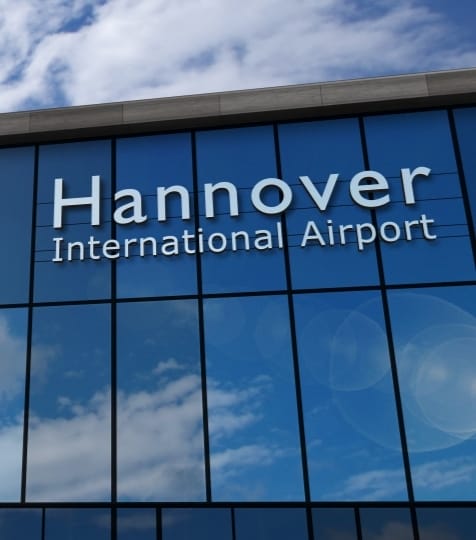 Gebäude - Spiegelt den Himmel - Große Fensterfront mit der Aufschrift "Hannover International Airport".