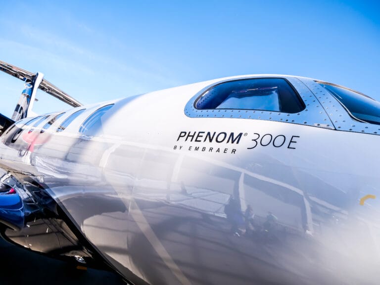 A white airplane featuring the word "phenon" prominently displayed on its side at the AERO 2025