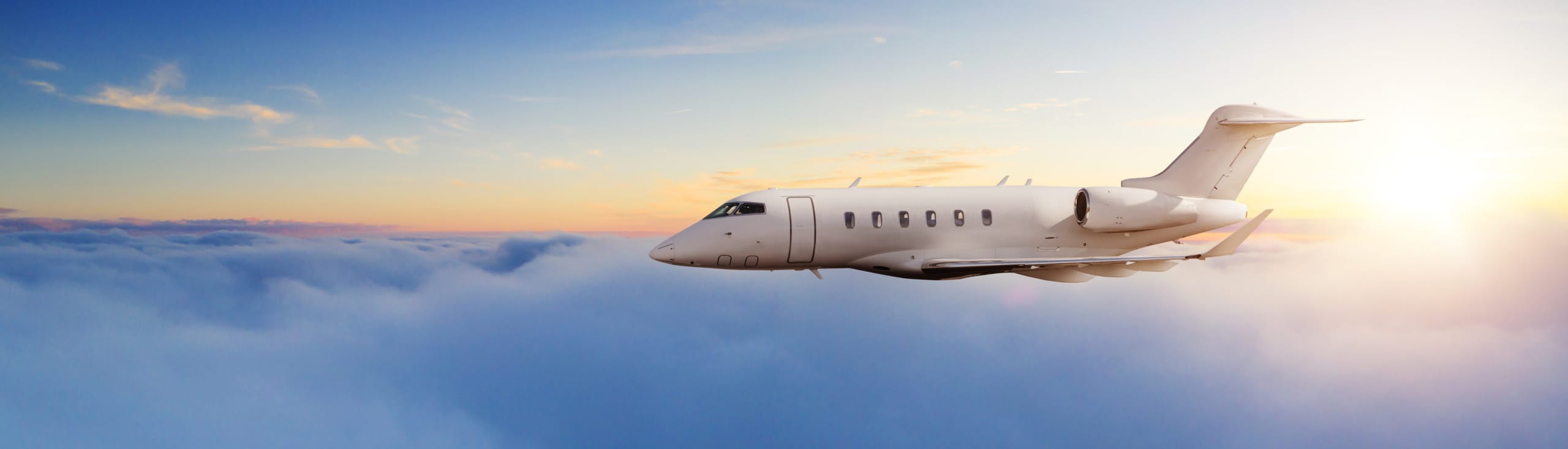 Privatjet Flugzeug fliegen über Wolken in schönem Sonnenuntergangs-Licht.